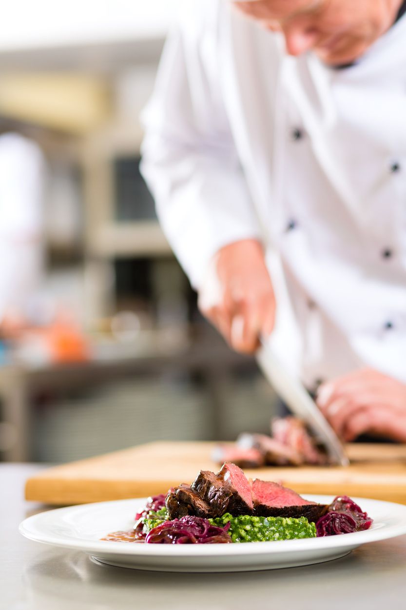 Koch richtet Teller mit Essen an